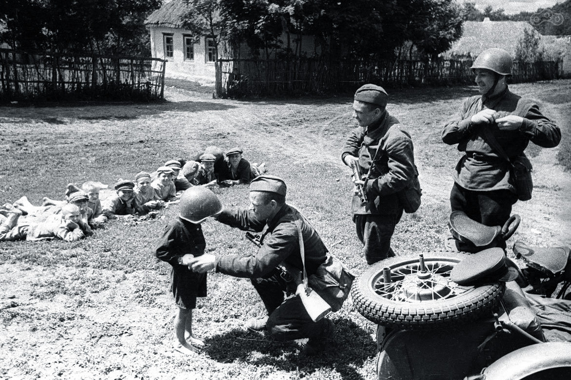 Дети освобожденных деревень и солдаты Красной Армии на мотоциклах 